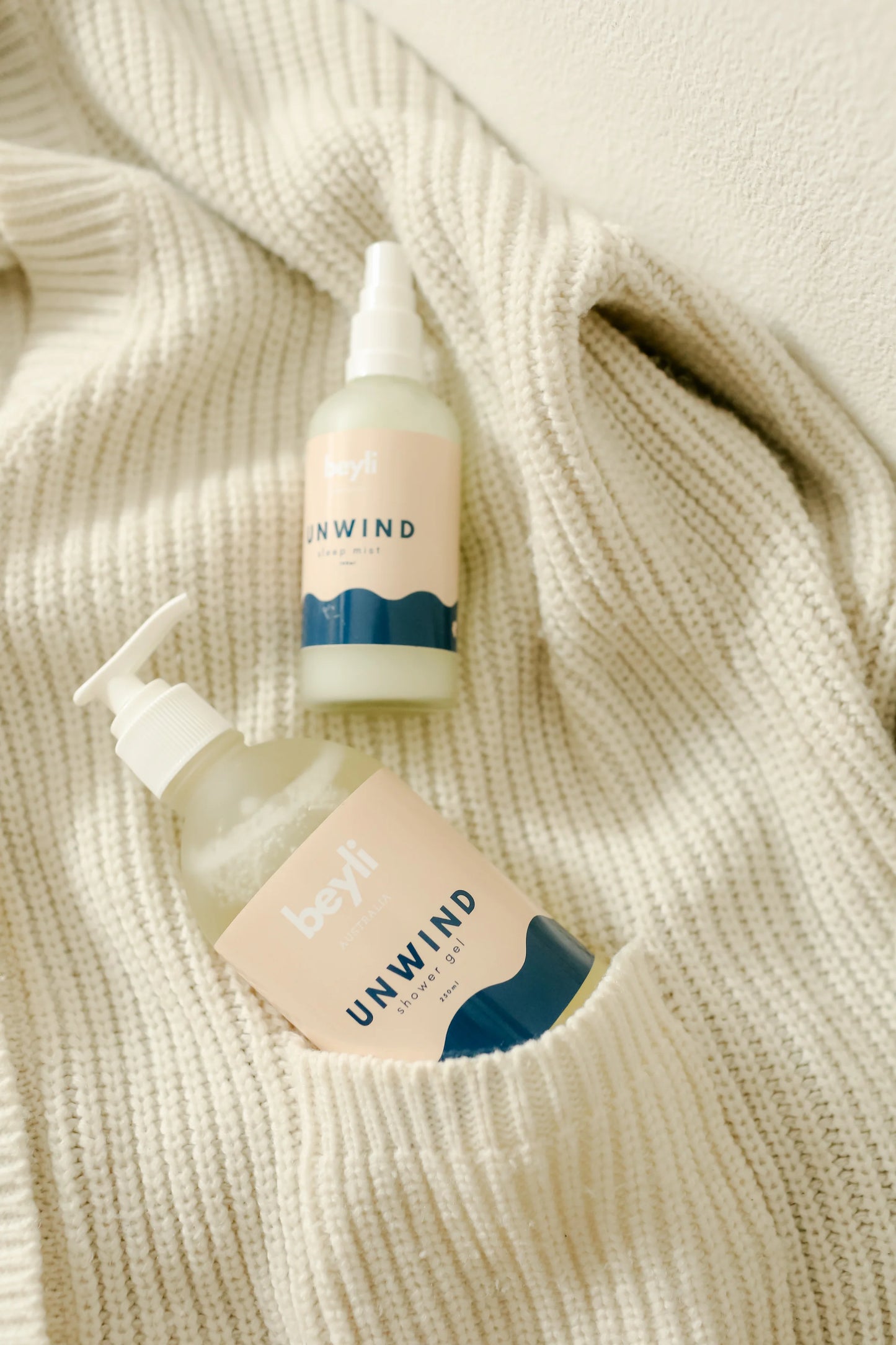 Sleep Bundle Essentials hand lotion duo beside a cozy white sweater