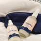 A set of sleep aid products with a mist bottle on a cozy bed setting