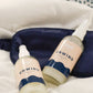 Pair of Sleep Bundle Essentials unwind lotions on a comfortable bed